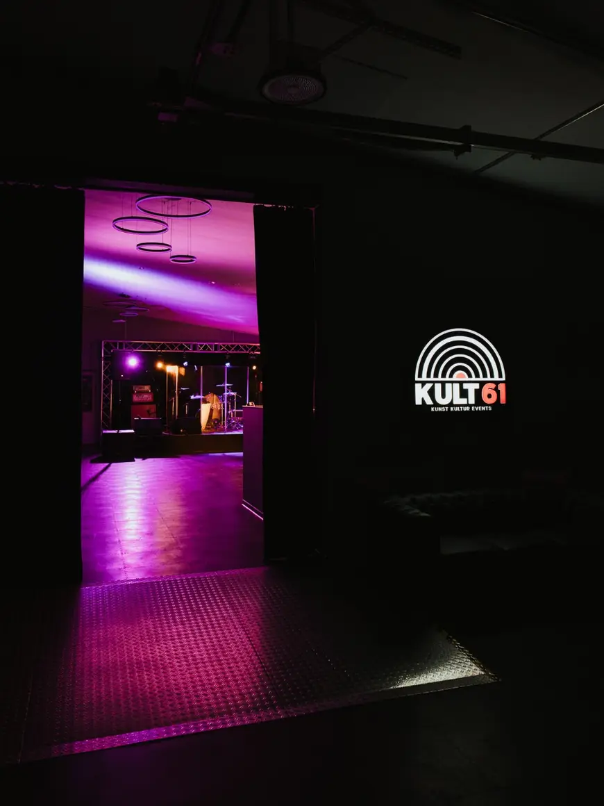 Durchgang zum Veranstaltungsraum im KULT61 mit Logo an der Wand