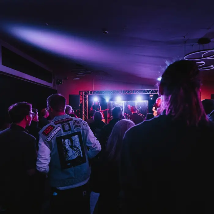Publikum vor der Bühne im KULT61, Konzert in lila und blauem Licht